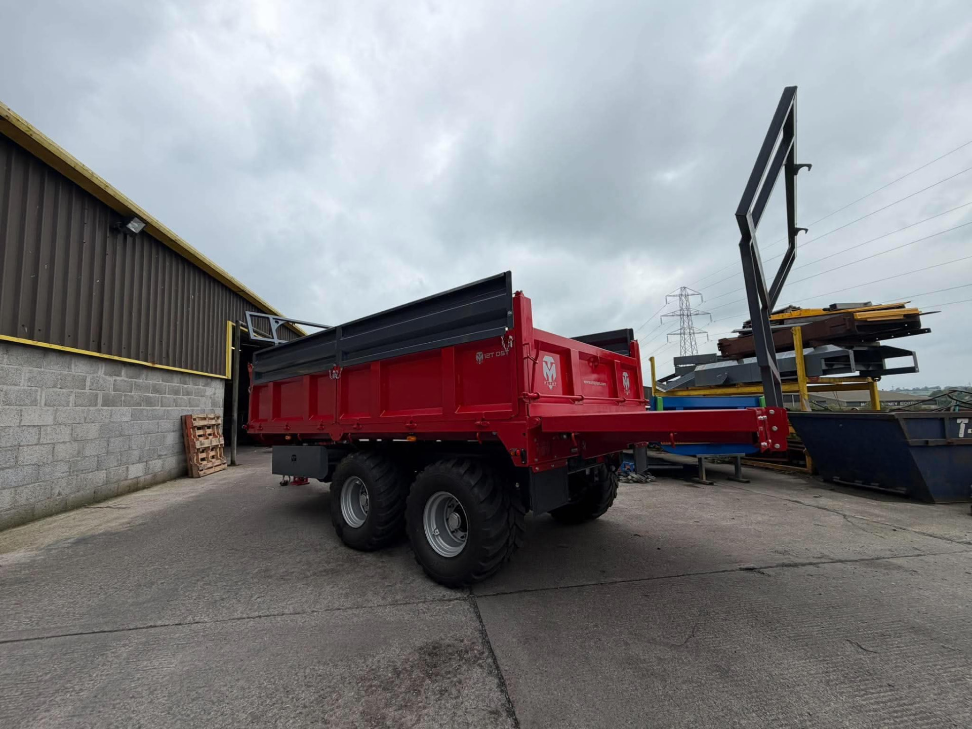 Rear three-quarter view of a red MT Plant 12T DST trailer outside the workshop