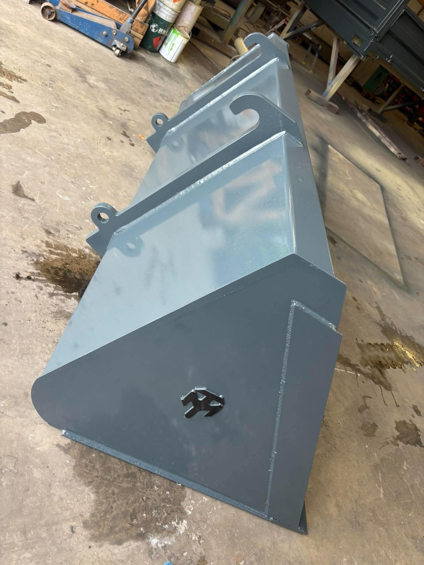 Newly painted grey MT Plant loader bucket on the workshop floor
